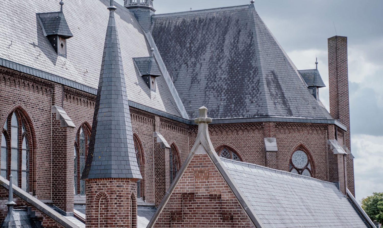 Leonarduskerk in Beek en Donk: monumentale bakstenen kerk met leien daken en torentjes